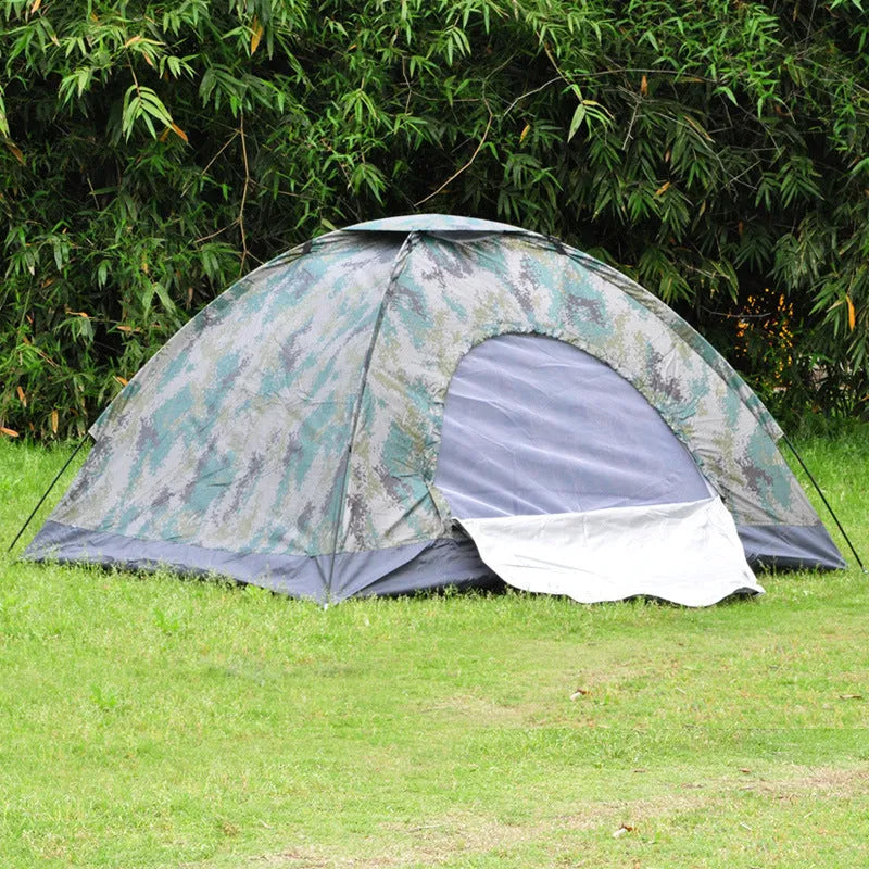 Green camouflage two-person camping tent with fibreglass poles pitched outdoors