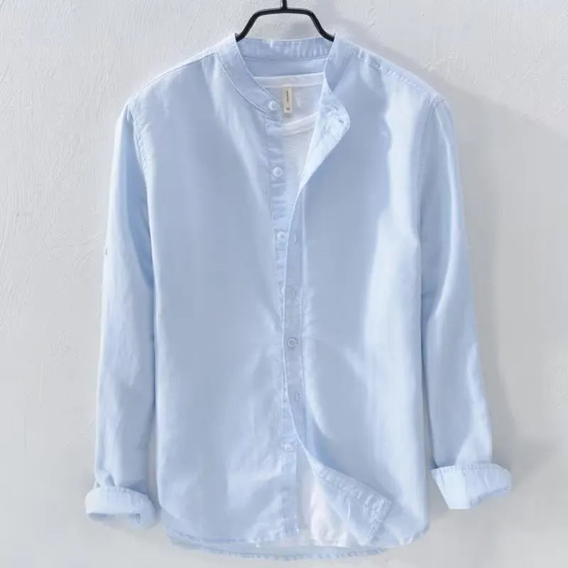 Man wearing a loose fit light blue linen blend long sleeve casual button-down shirt.