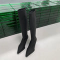 Black women's pointed toe below knee boots with a stiletto heel and a back zip fastener.