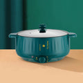 White stainless steel electric hot pot with non-stick interior on a kitchen countertop.