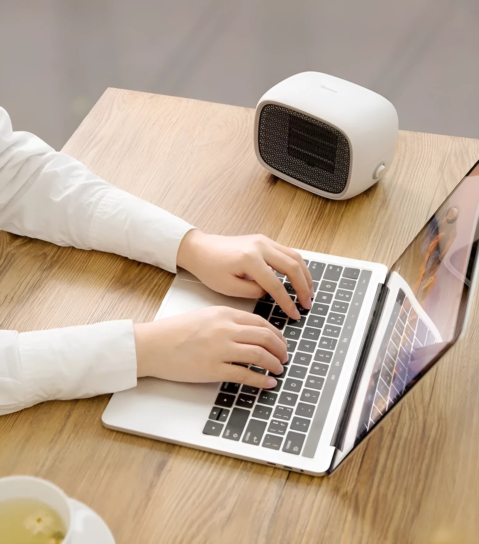 Compact green mini ceramic heater with metal mesh grille on a desk