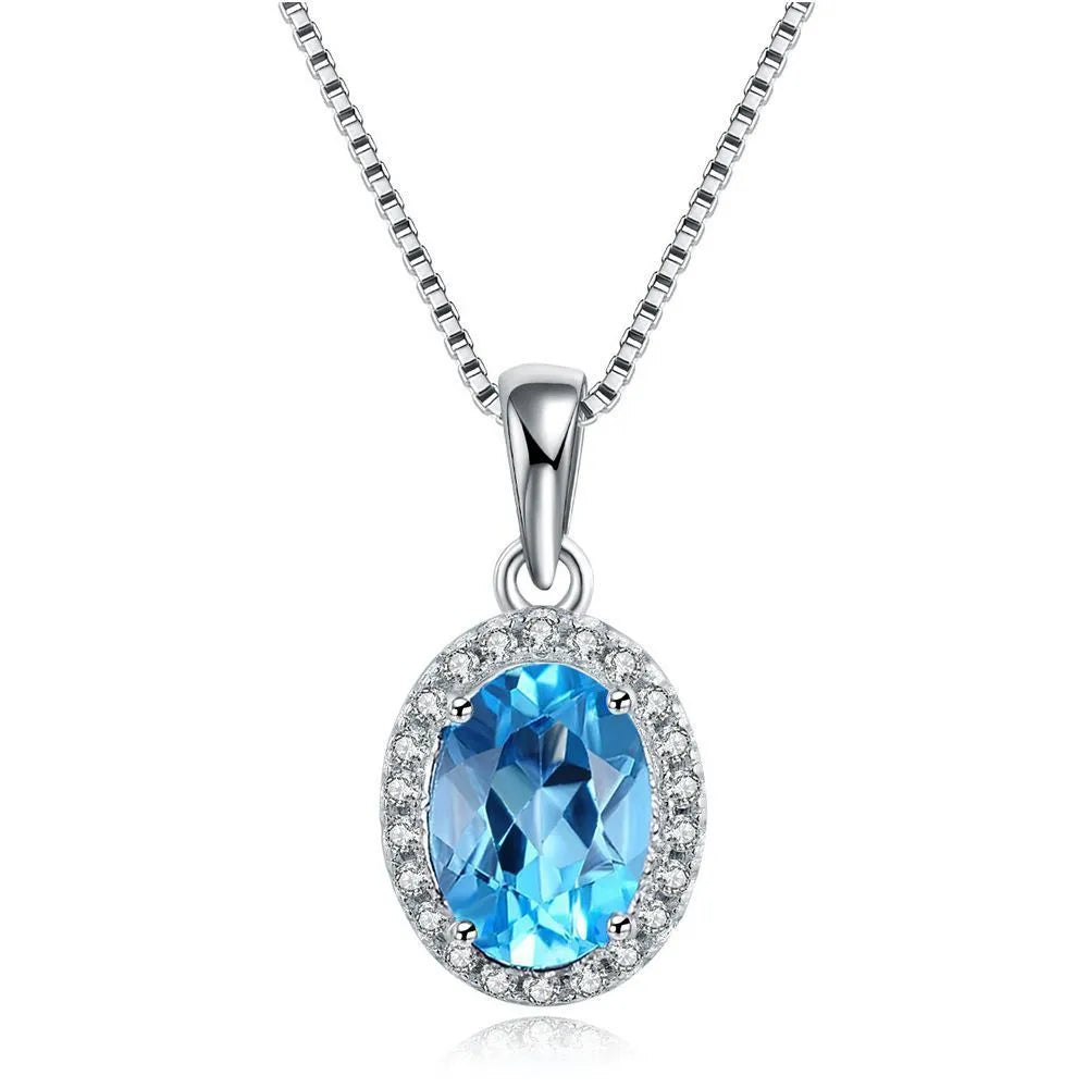 Four-piece sterling silver jewellery set with blue topaz stones: geometric earrings, ring, pendant, and necklace.