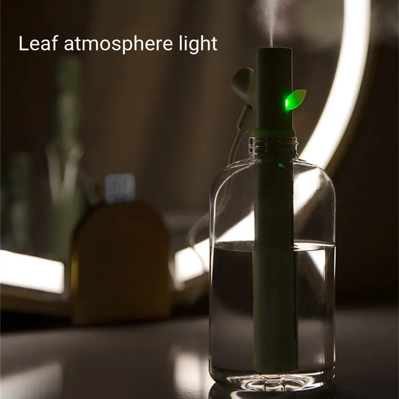 Transparent plastic branch-shaped USB portable air humidifier on a desk.