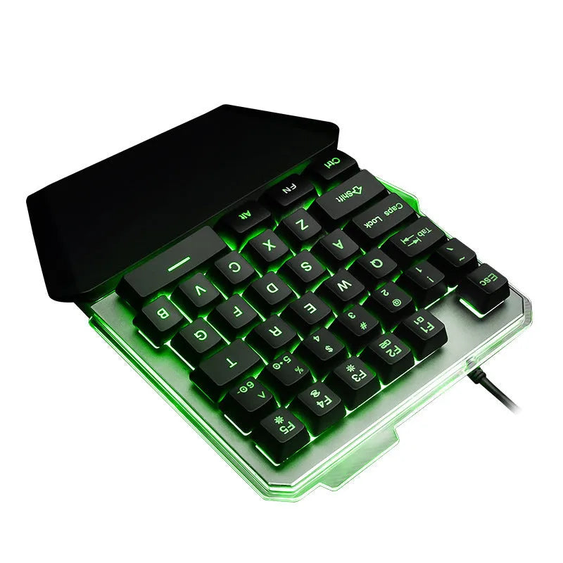 Black one-handed robotic gaming keyboard with RGB backlit keys on a desk.