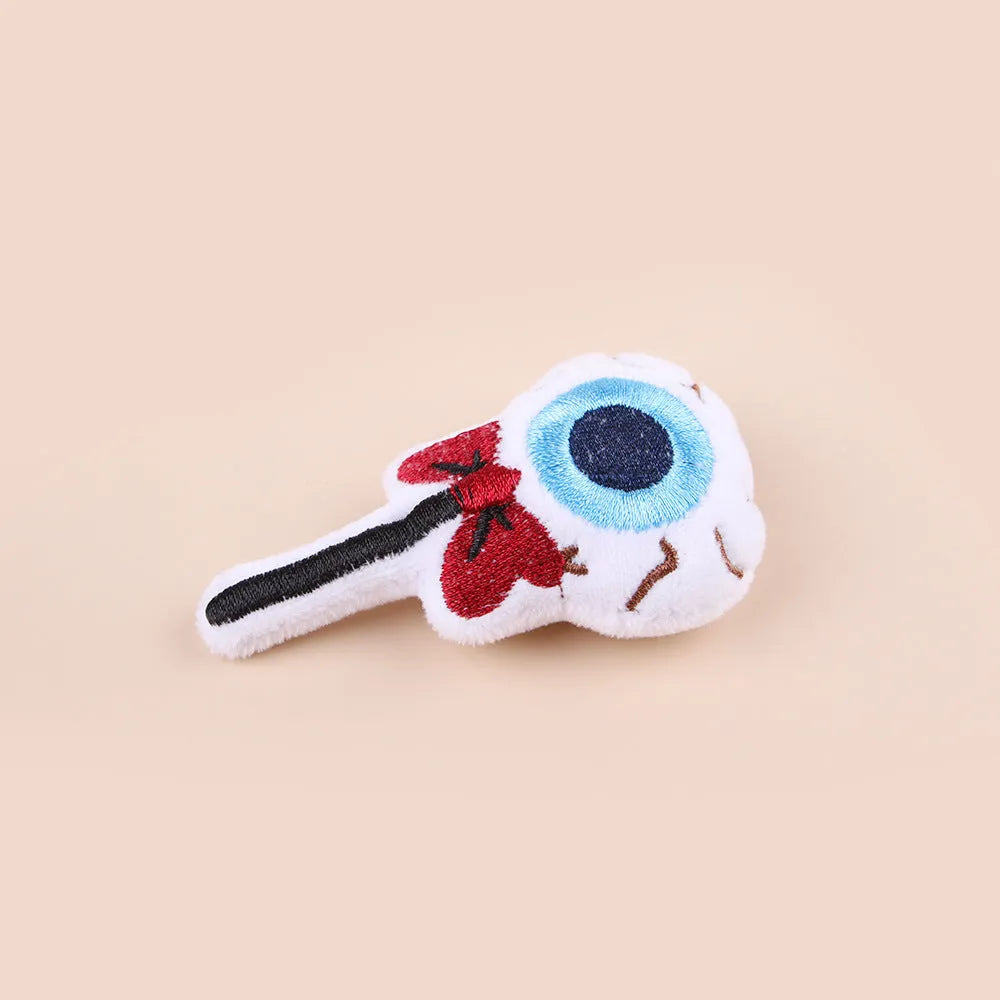 Small plush cat teaser wand toy showing candy, skull and eye patterns on soft fabric