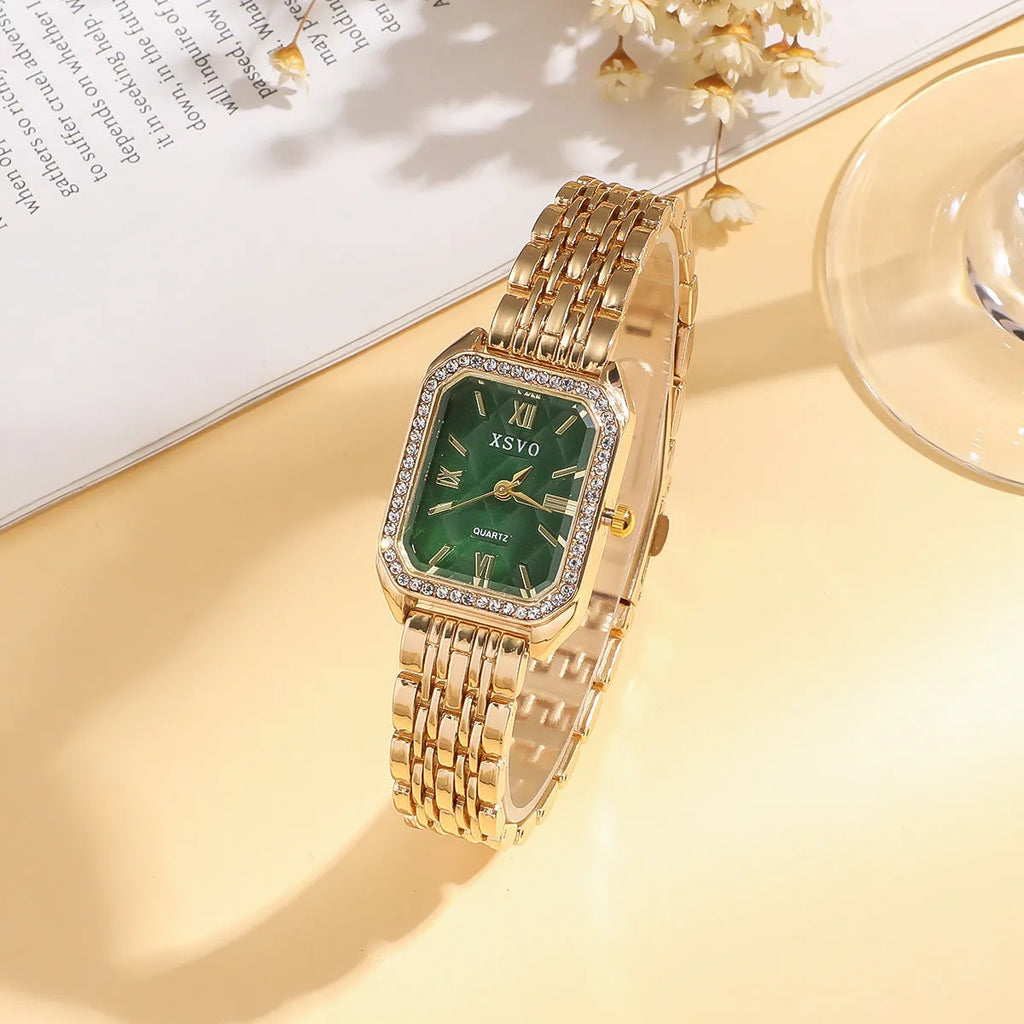 Gold green square steel ladies watch and four matching butterfly jewellery bracelets laid out as a set.