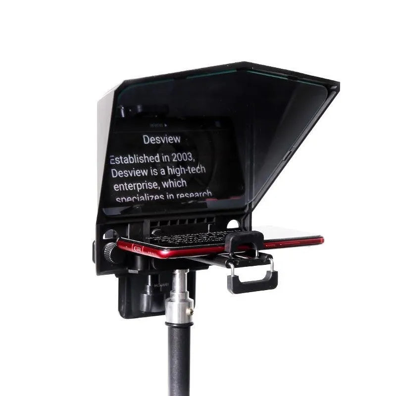 Portable small black cell phone teleprompter with adapter rings and remote control on a table