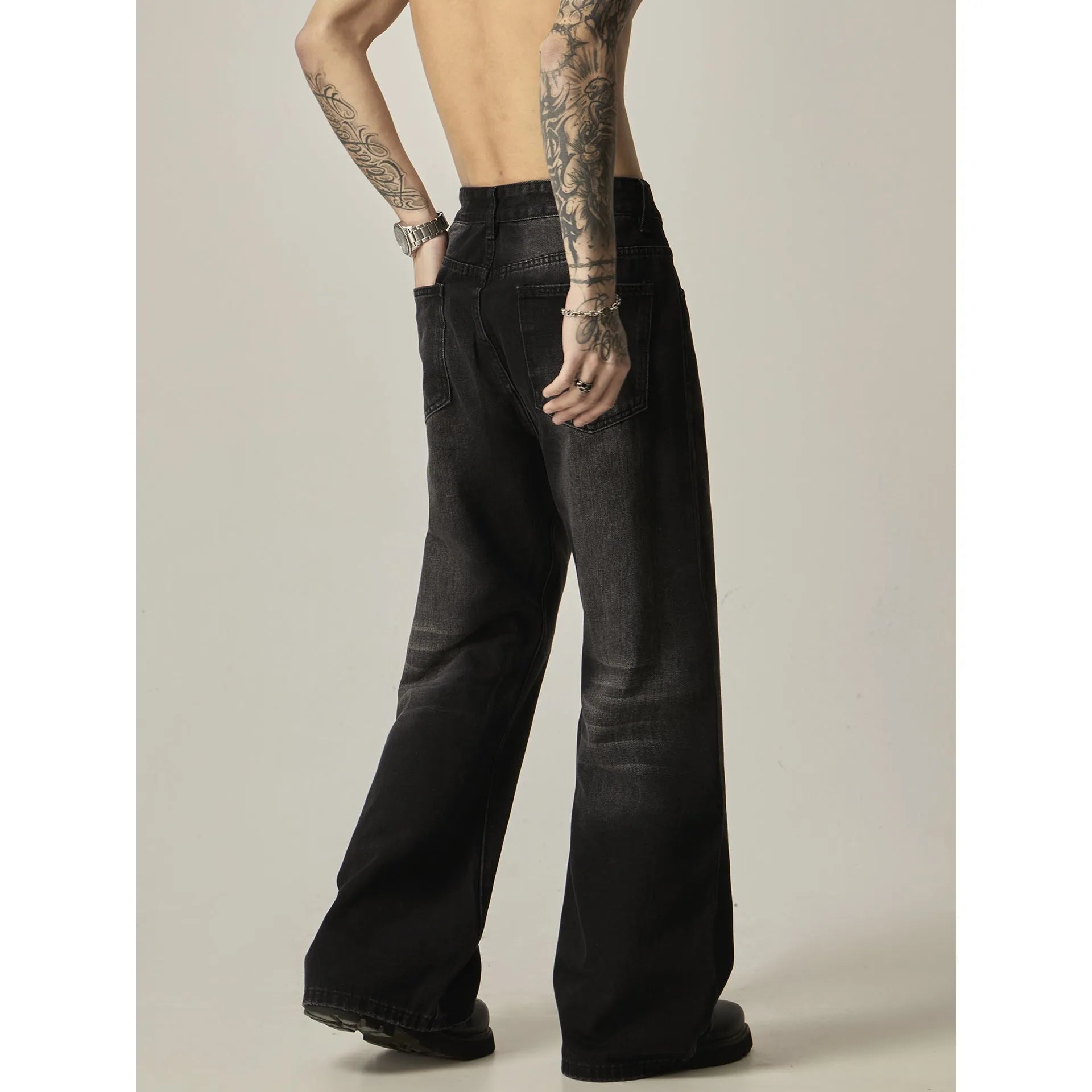 Black loose fit straight leg retro jeans on a hanger, showing zipper fly and relaxed silhouette.