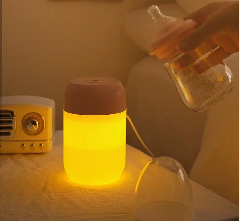 White cylindrical mini USB humidifier on wooden surface with charging cable