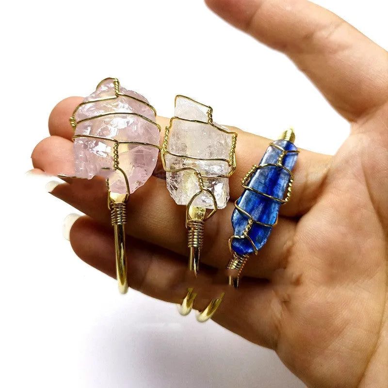 Natural rough crystal bracelet with gold geometric winding on a wrist, showing bohemian style.