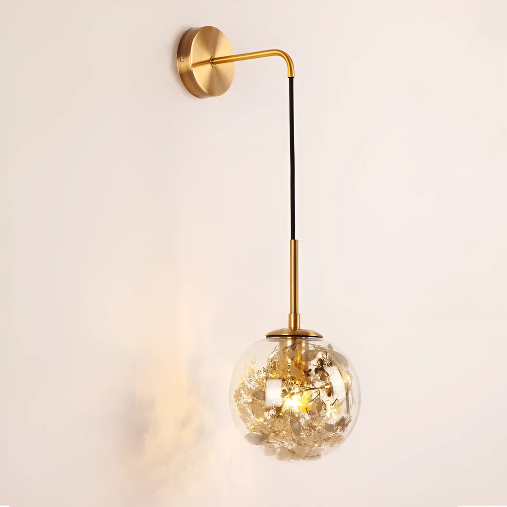 Modern glass wall lamp in golden flower finish mounted beside a bed.