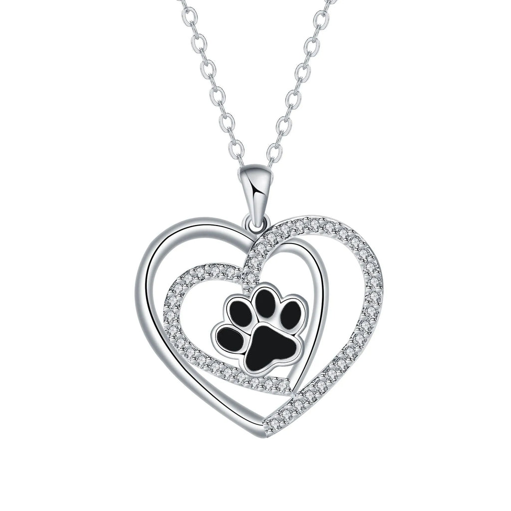 Close-up of a heart-shaped copper necklace pendant featuring a detailed dog's paw print design on a cross chain.