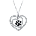 Close-up of a heart-shaped copper necklace pendant featuring a detailed dog's paw print design on a cross chain.