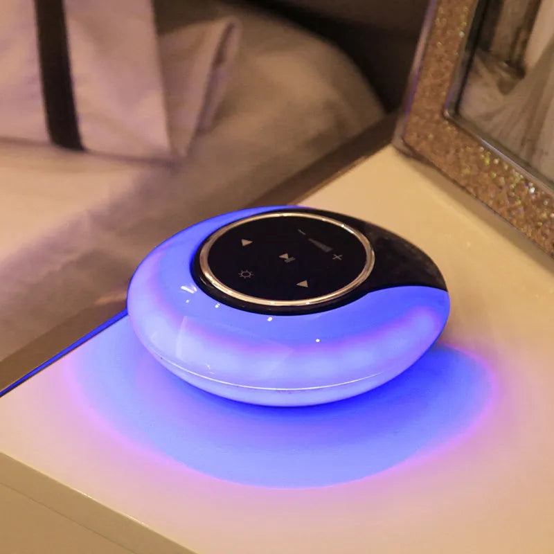 Blue cubic Bluetooth desk lamp speaker with touch controls and folding head on wooden desk