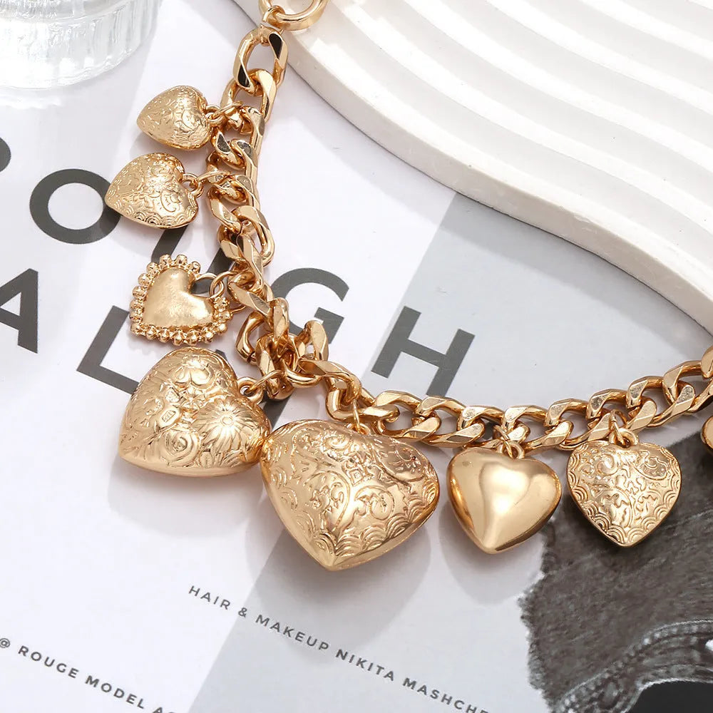 Carved heart pendant necklace in gold finish with exaggerated style on metal chain