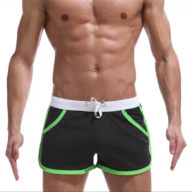 Summer men's quick-dry polyester sports shorts in multiple colours including black, green, and red for beach and casual wear.
