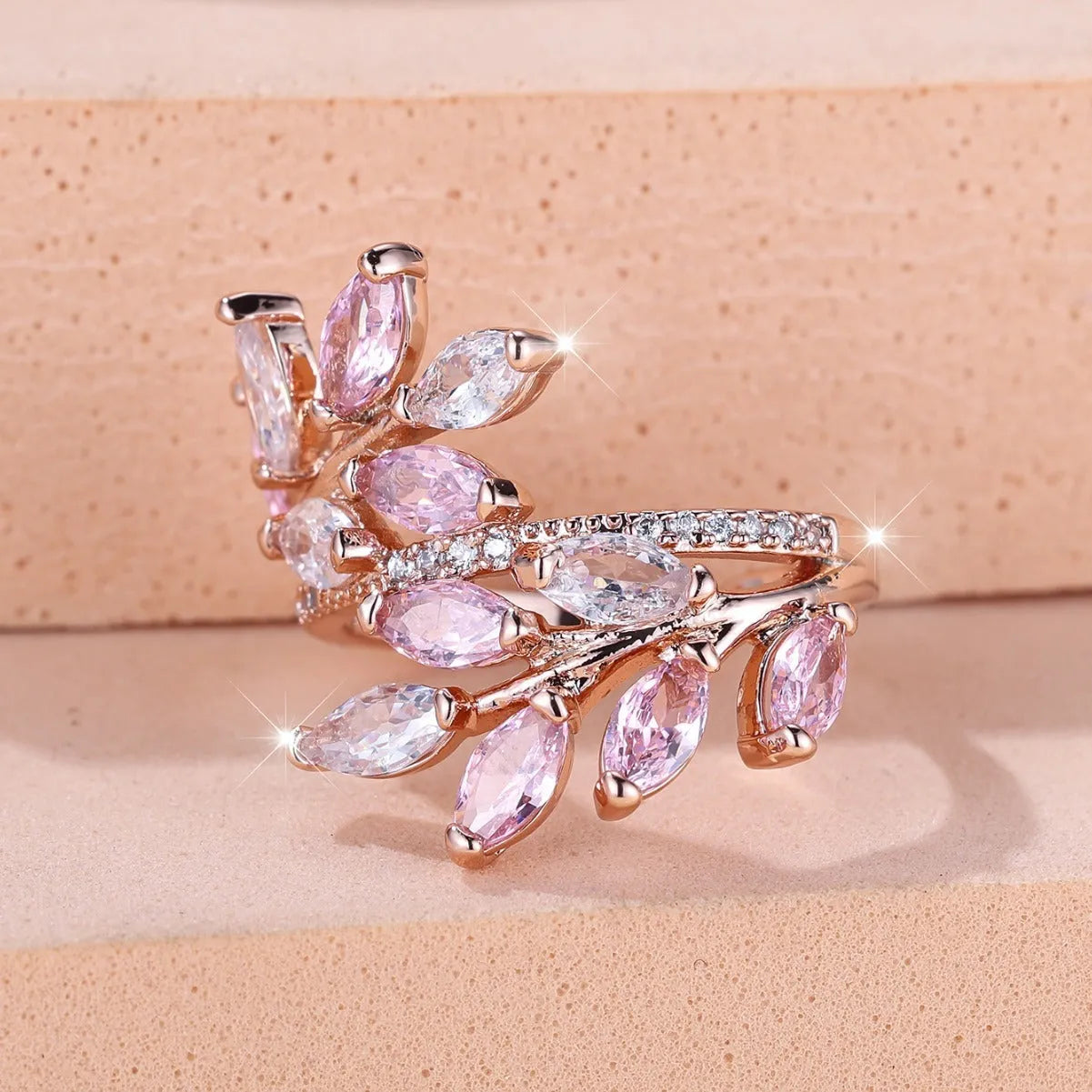Adjustable copper leaf-shaped ring with zircon gemstone colour options on a white background.