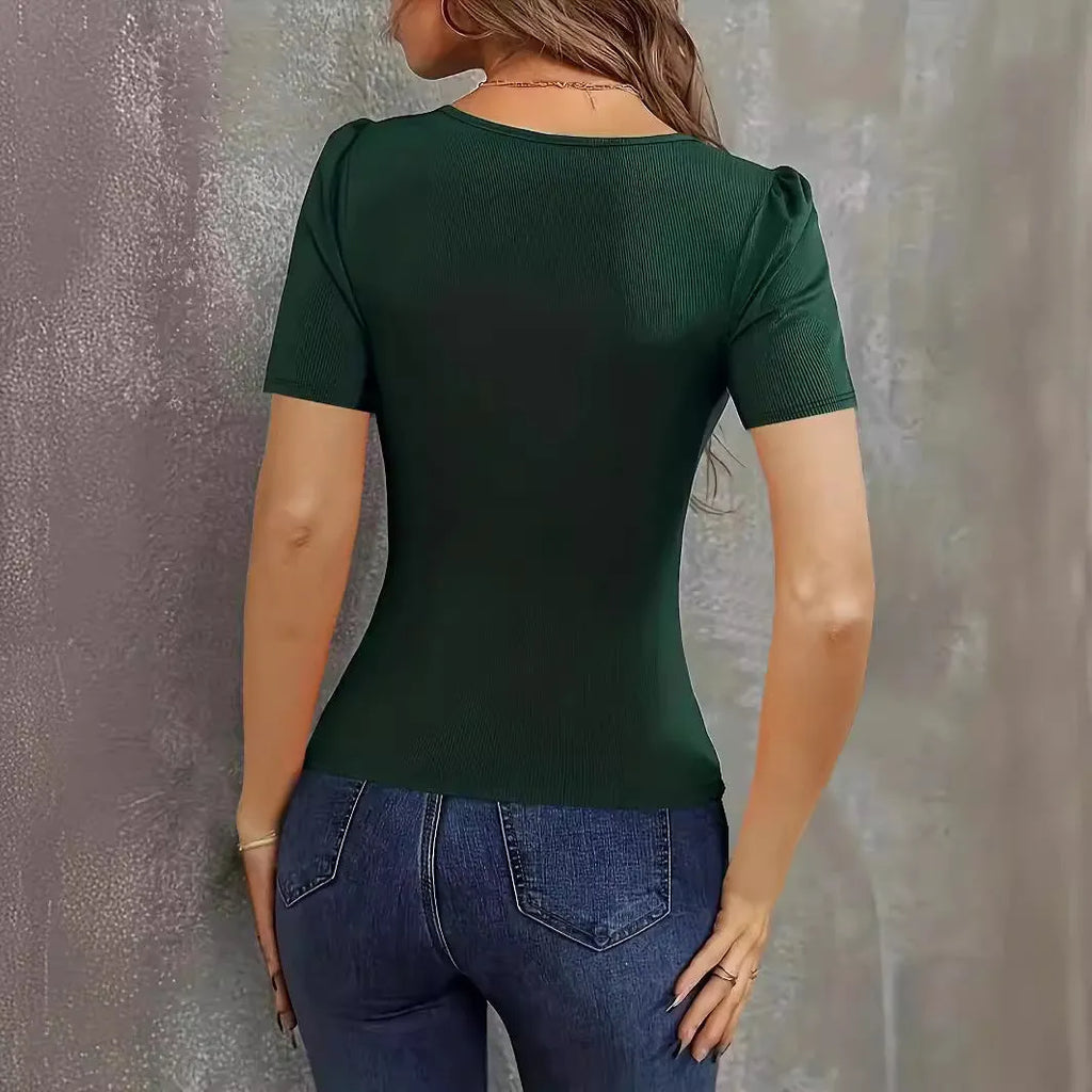 Woman wearing a wine red knitted short sleeve top with a low neckline and slim fit.