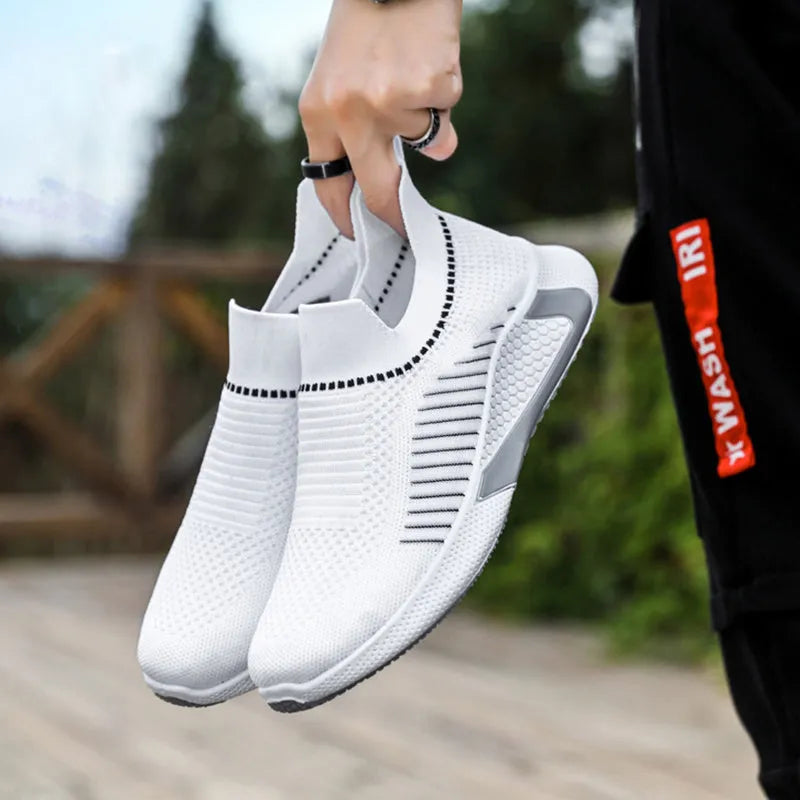 Men's black and white striped mesh slip-on sneakers with lace-up front on a plain background.