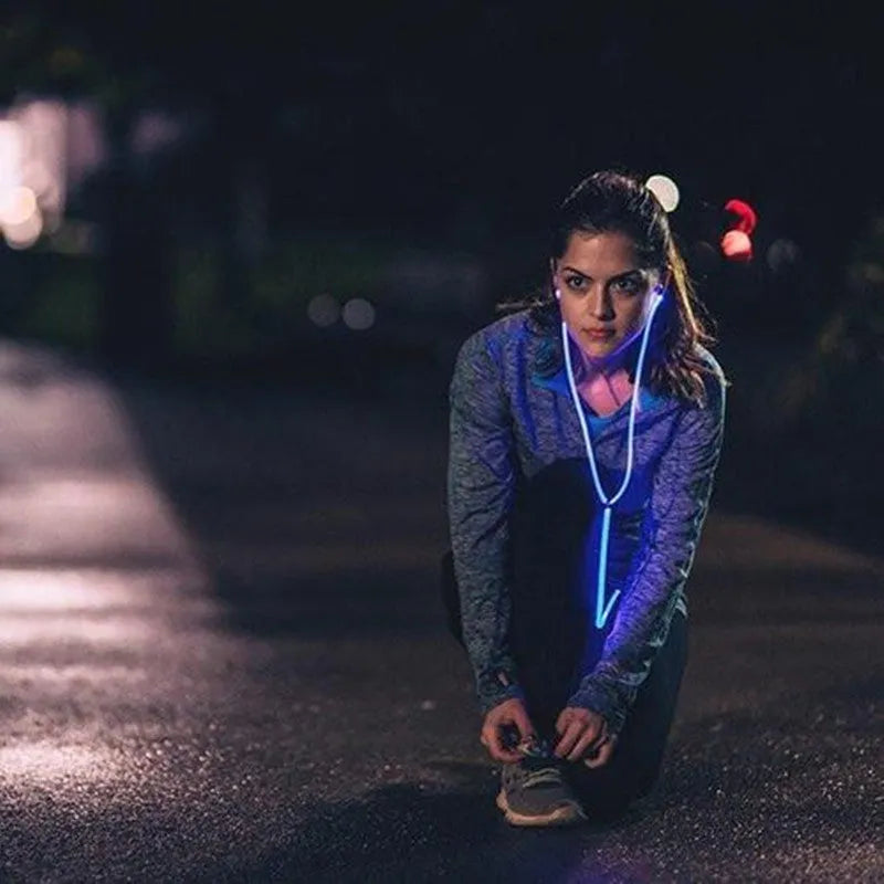 Blue LED light up earphones with 3.5mm plug and inline remote control on a dark background.