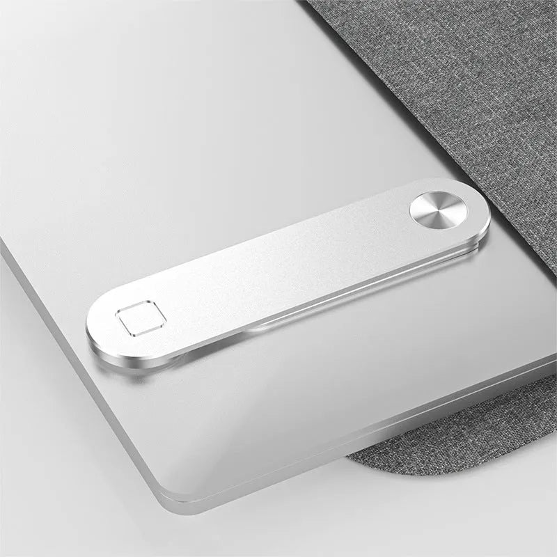 Black magnetic phone holder clipped to the side of a silver laptop, showing a smartphone attached.