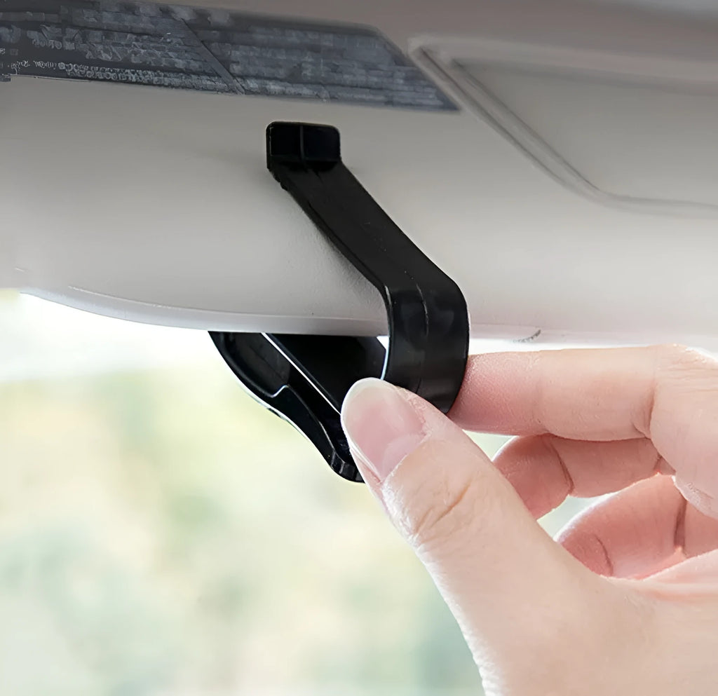 Black plastic multifunctional clip for car sun visor to hold sunglasses, tickets, and ID cards.