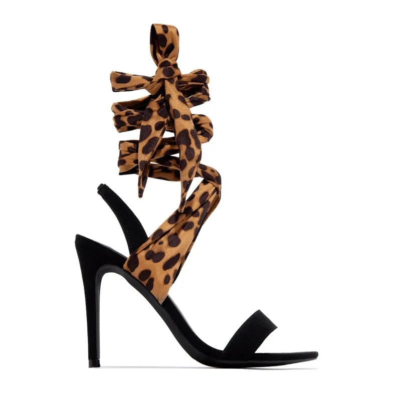 Light brown leopard print women's high heel sandals with cross straps and a tall thin heel.