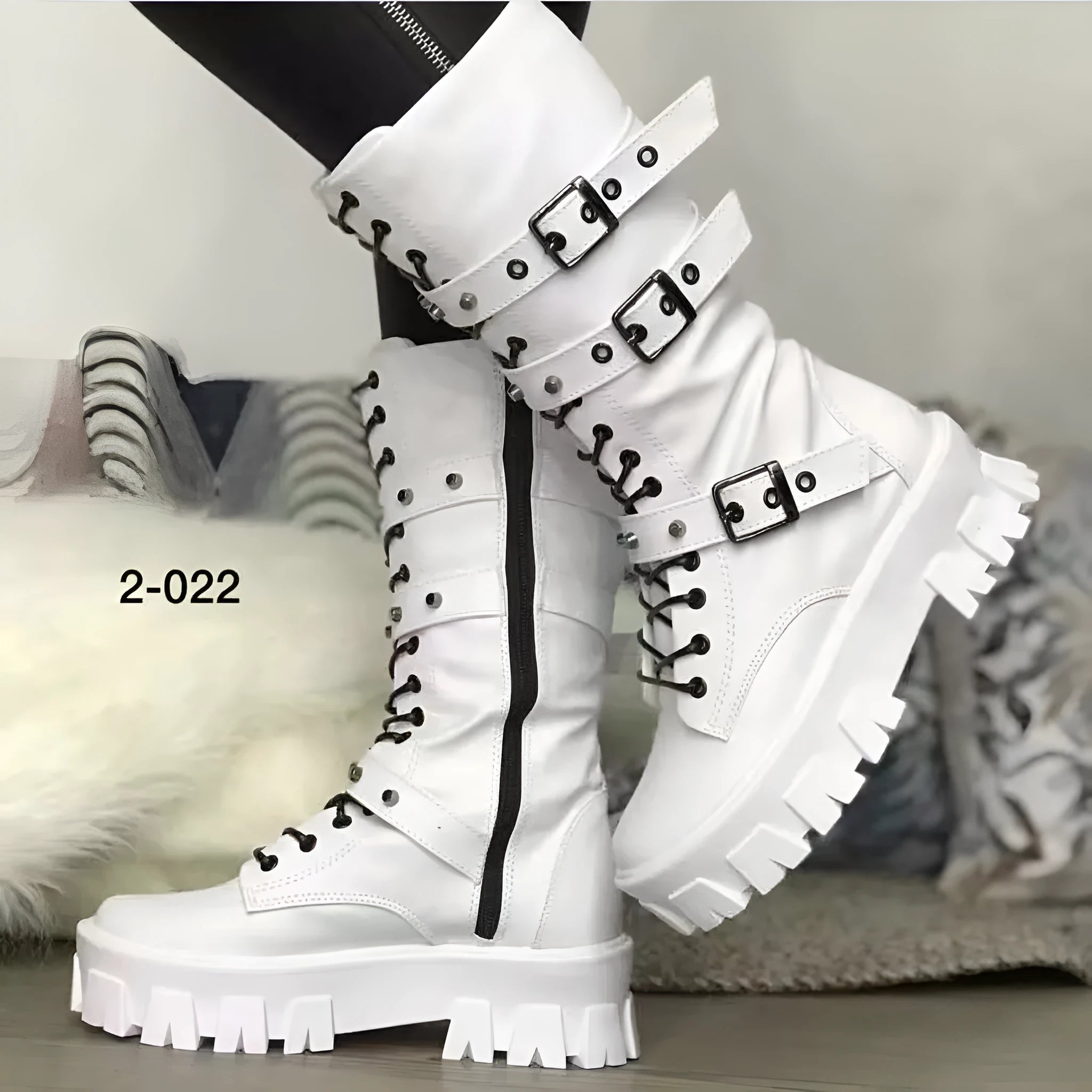 A pair of black mid-calf women's boots with metal buckle details and a side zipper on a white background.