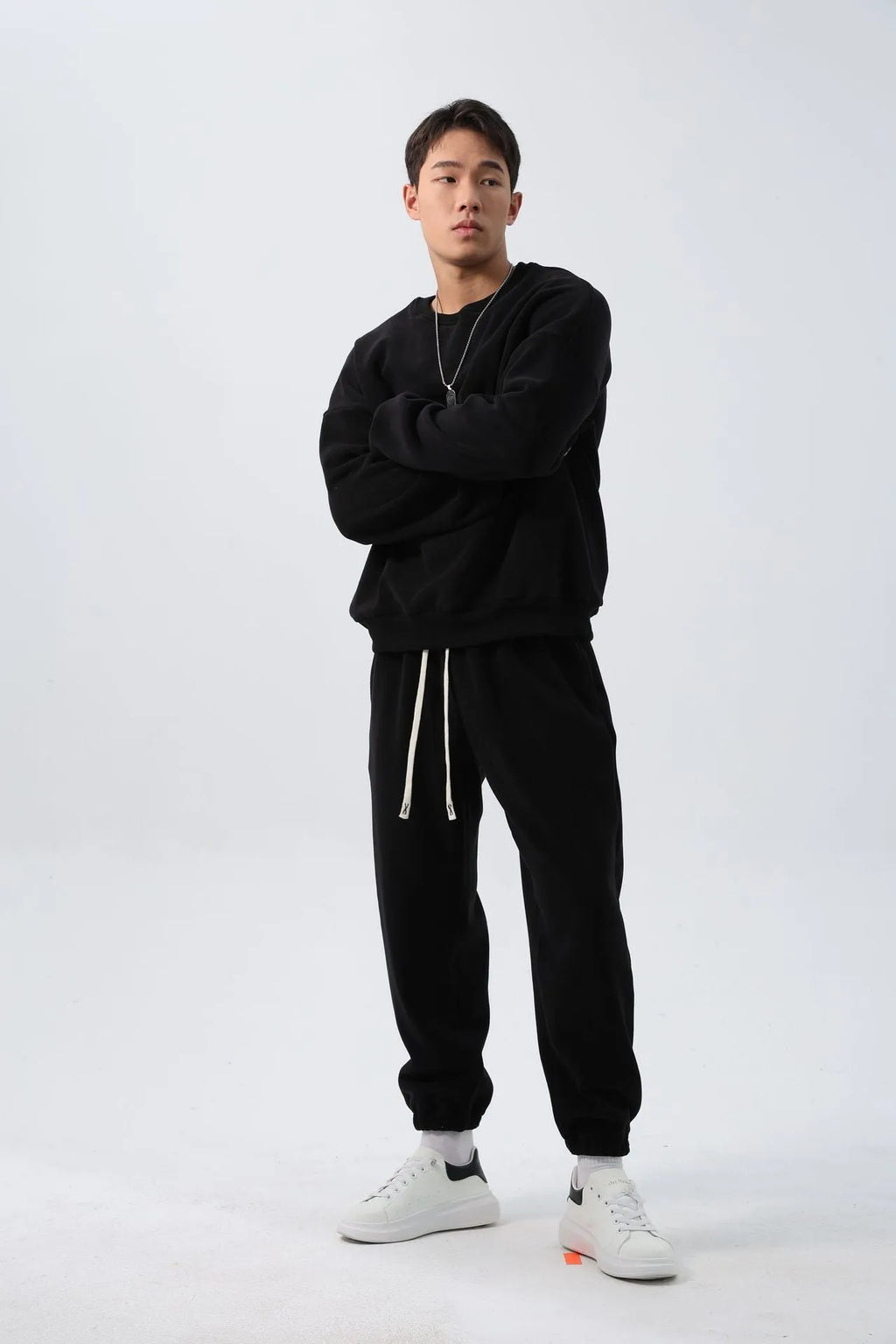 Man wearing a grey polar fleece crew neck coat and matching padded trousers from a casual winter sport suit set.