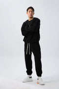 Man wearing a grey polar fleece crew neck coat and matching padded trousers from a casual winter sport suit set.