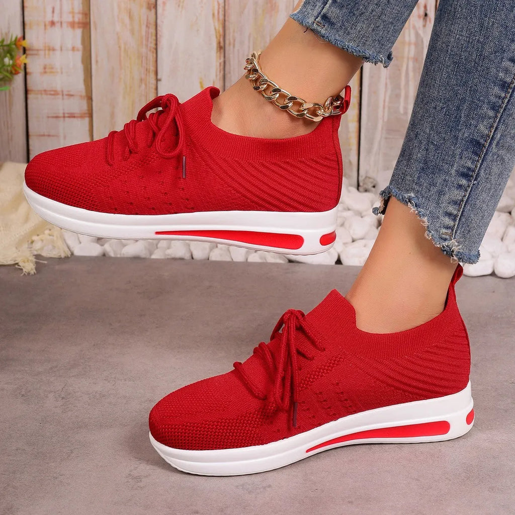Women's low-top fly-knit sneakers in red with front lace-up closure and round toe.