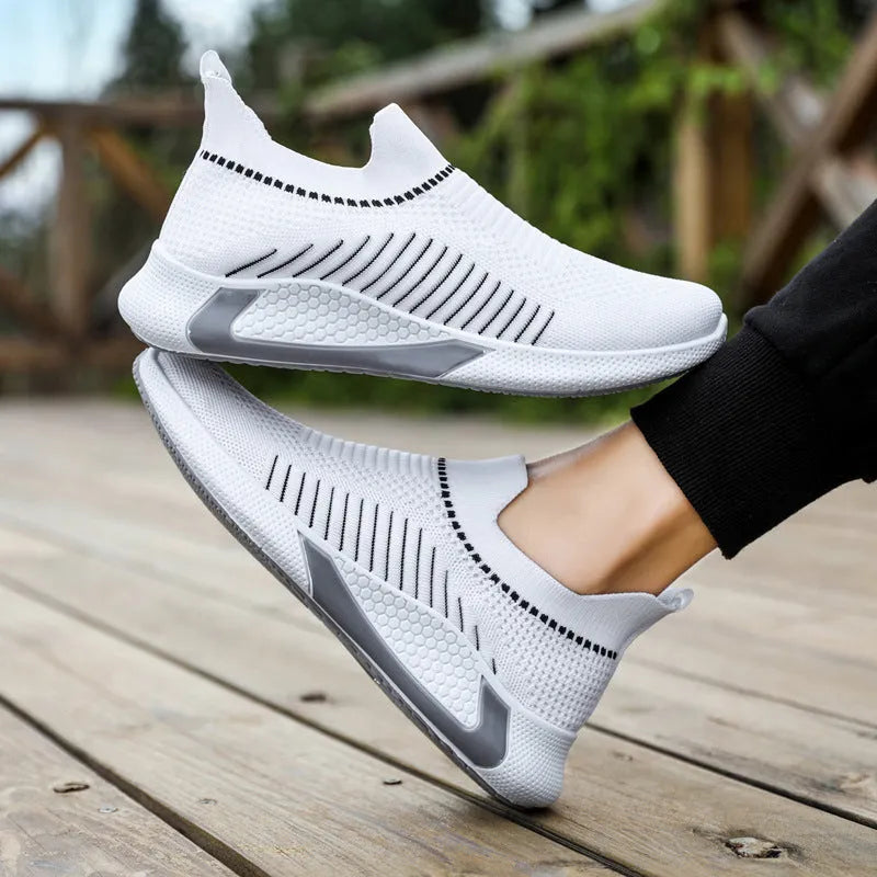 Men's black and white striped mesh slip-on sneakers with lace-up front on a plain background.