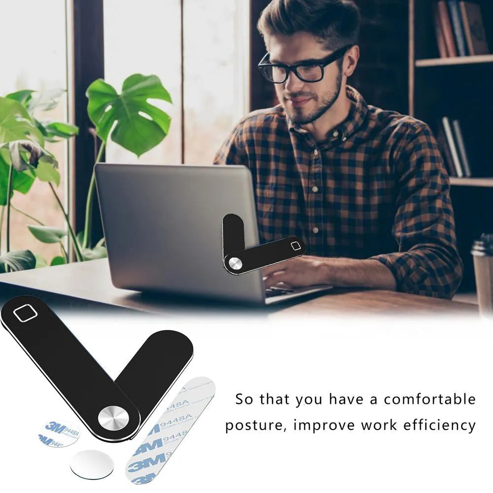 Black magnetic phone holder clipped to the side of a silver laptop, showing a smartphone attached.