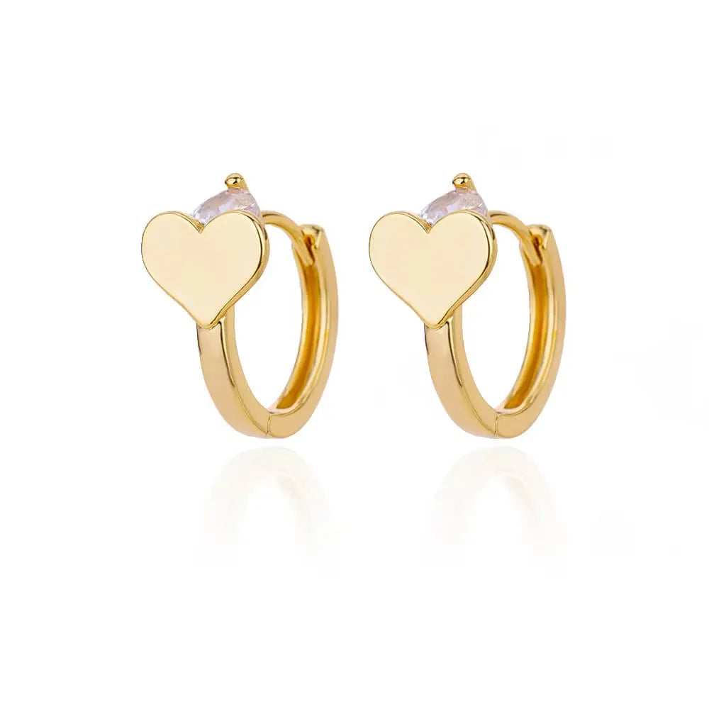 Gold and clear heart-shaped clip-on earrings with a zircon stone on a white background.