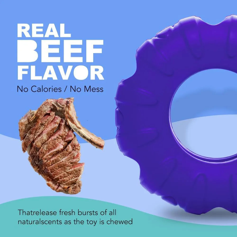 Blue rubber tyre-shaped dog chew toy and slow feeder with oval openings on a wooden floor.