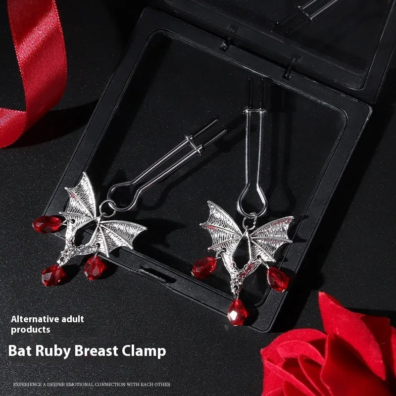 Silver alloy bat-shaped nipple clamp with ruby details and adjustable rubber-padded mechanism.