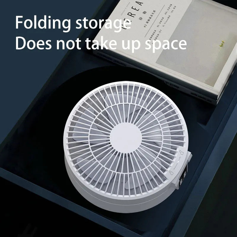 White rechargeable folding USB ceiling fan with remote control on wooden desk