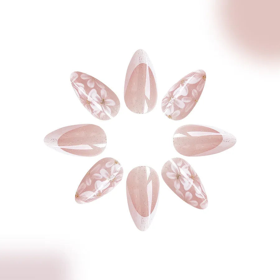 Short glossy almond-shaped false nails with glitter and flower French tip design, colour C625.