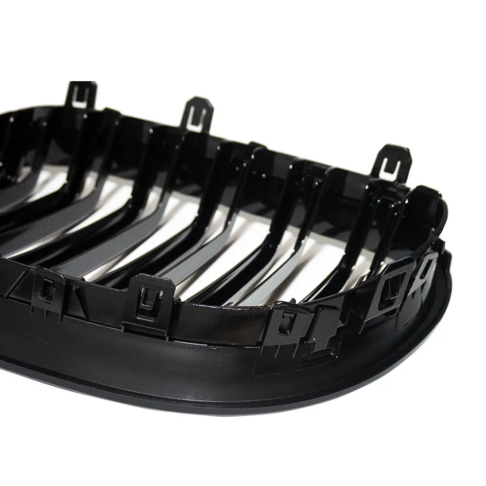 Pair of black carbon fibre pattern front grilles for a BMW 5-Series car.