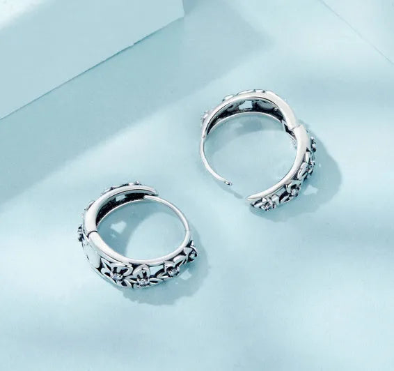Sterling silver retro hollow butterfly earrings with zircon accents on a white background.