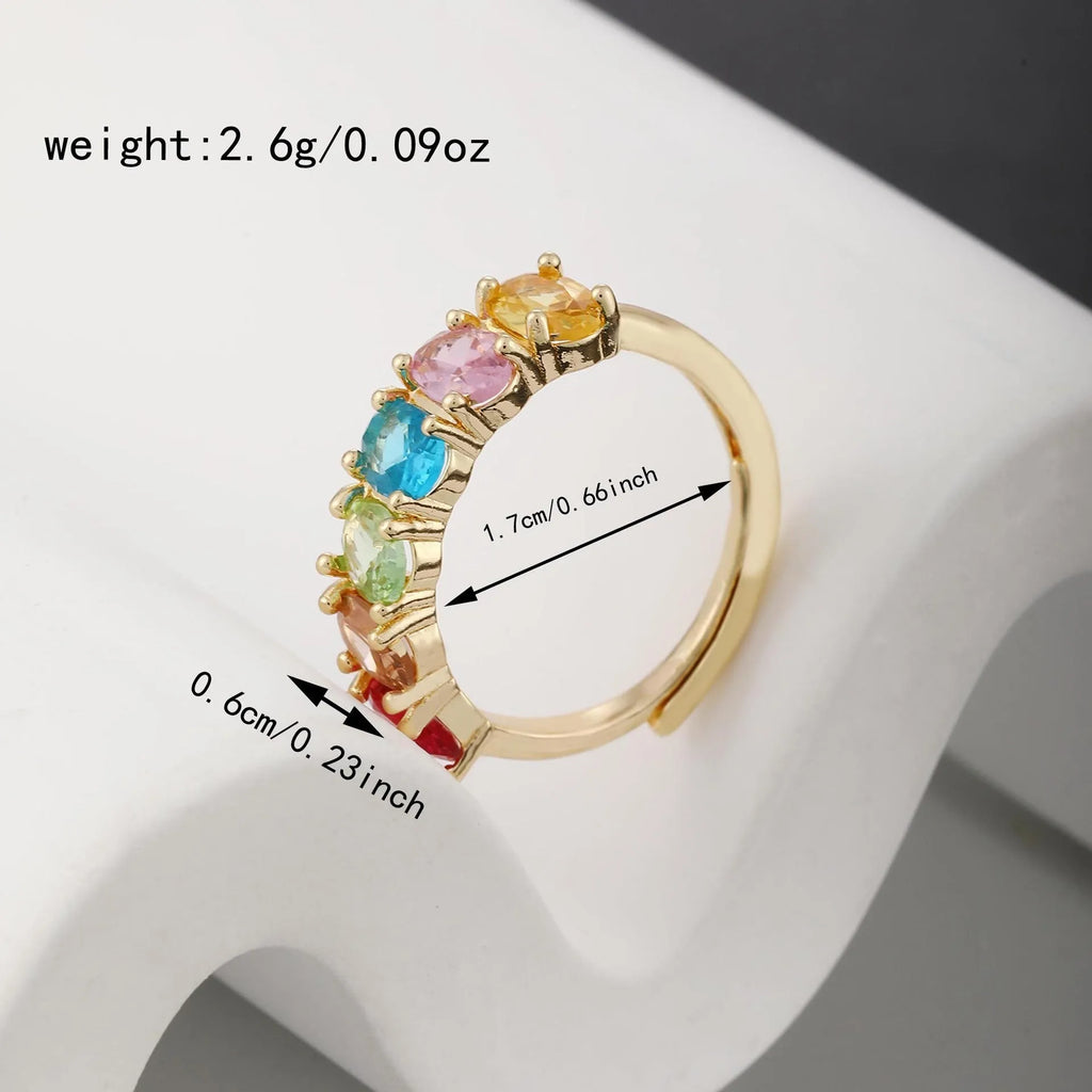 Gold coloured adjustable ring with zircon detail on a white background.