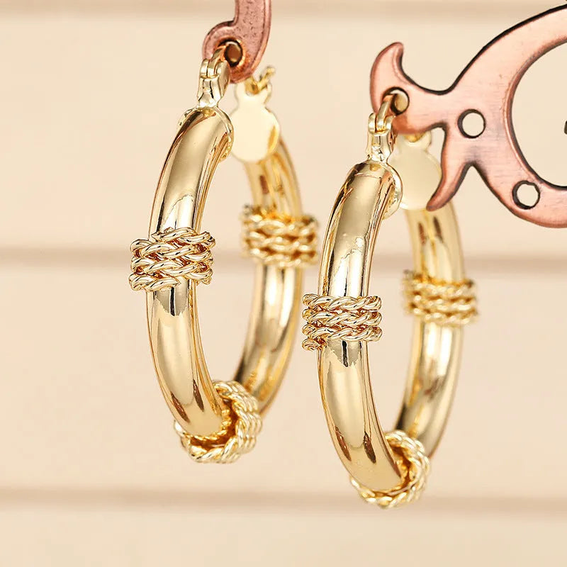 Golden geometric earrings with ring and line design elements on copper