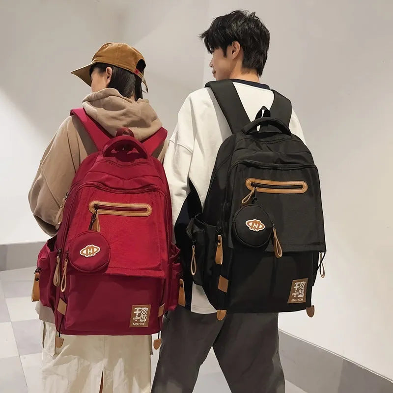 Large black nylon school backpack with curved shoulder straps, shown in a street style design for students.
