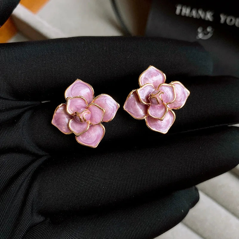 Close-up of gold plated purple oil-spot glaze flower stud earrings on copper base with needle post
