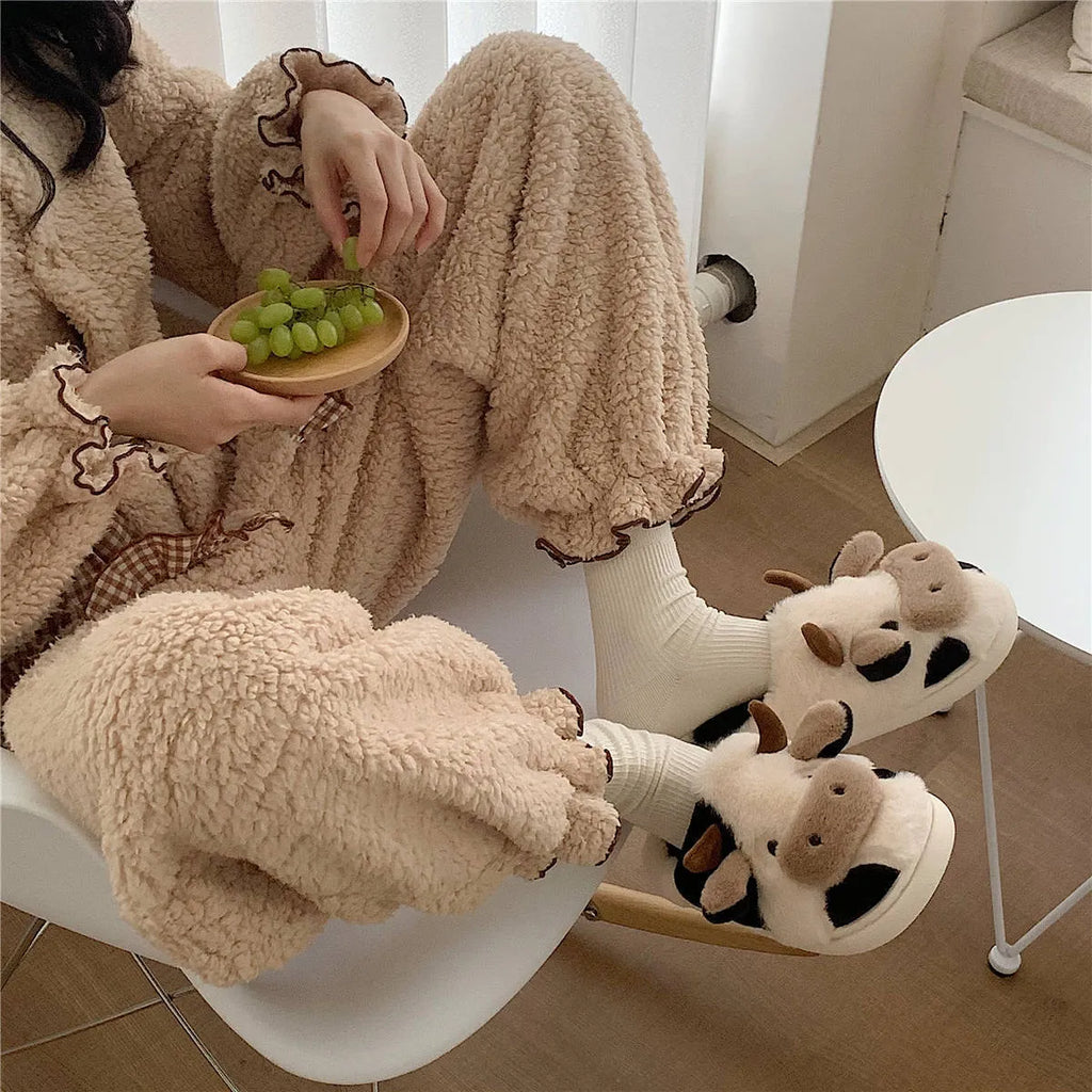 White cow-themed plush slippers for women with a non-slip textured sole.
