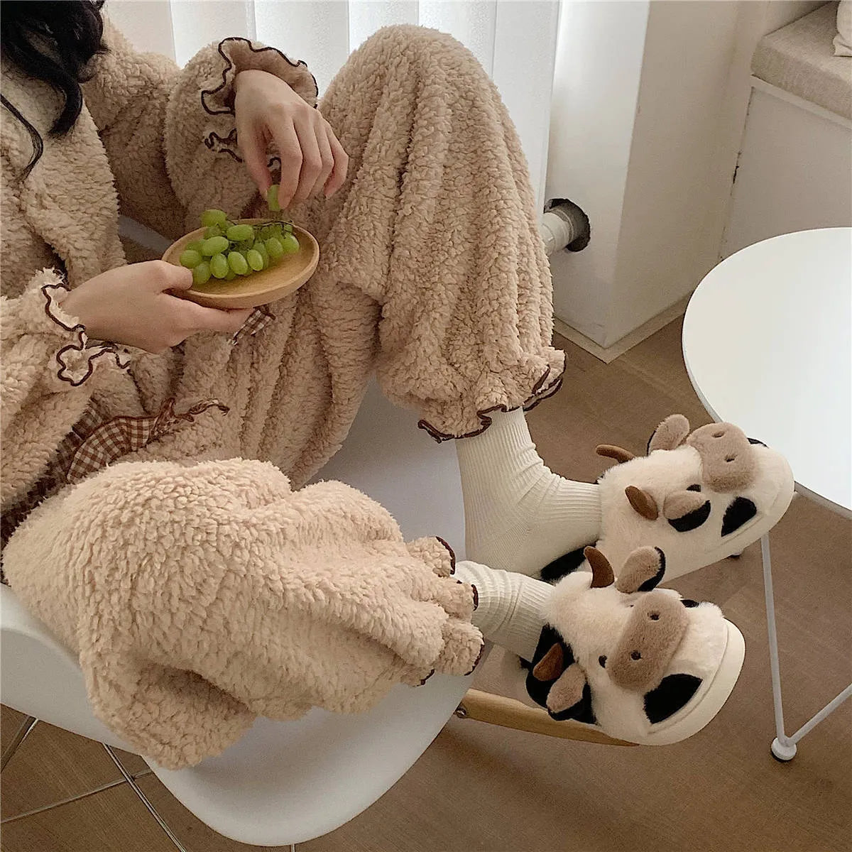 White cow-themed plush slippers for women with a non-slip textured sole.