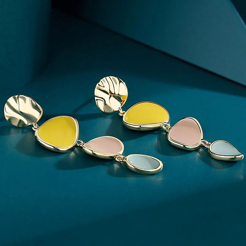 A pair of simple disc-shaped alloy earrings with a blended Morandi three-colour oil drip finish, showing a vintage wafer style.