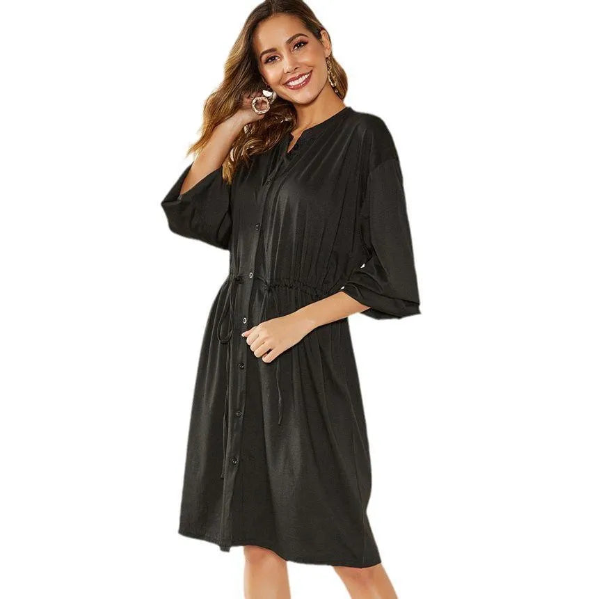 Black A-line midi dress with long sleeves, elastic waist, and a matching fabric belt.
