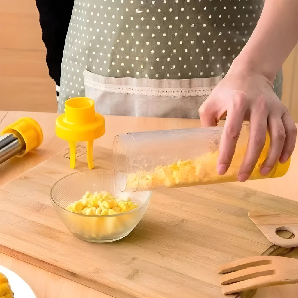 Yellow cylindrical corn stripper kitchen tool with stainless steel mechanism on a wooden surface.