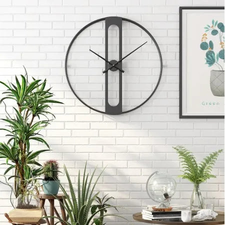Large 50cm round metal wall clock in black or gold colour on a wall.